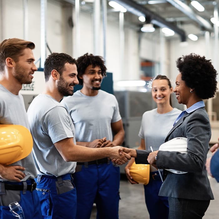 working team shaking hands with business dressed employee 