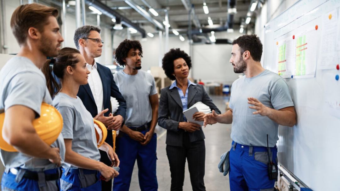 Warehouse team huddled at a whiteboard