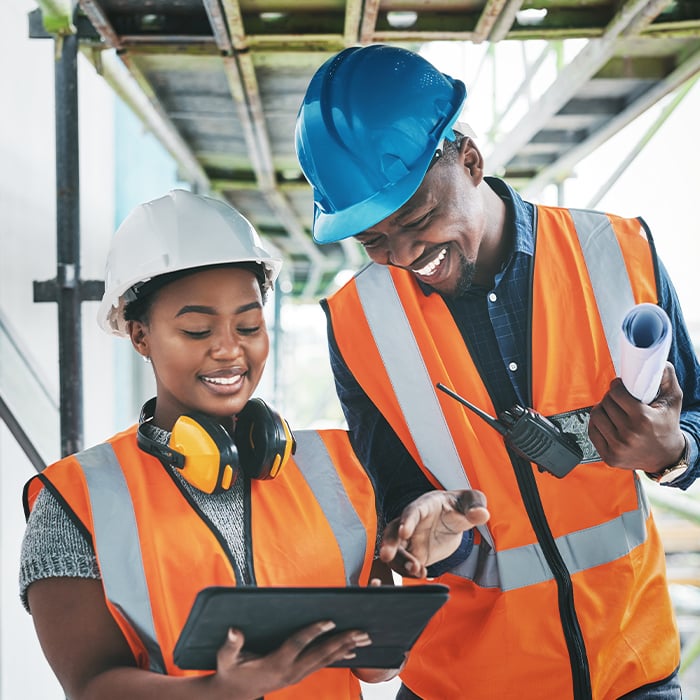 construction workers looking at tablet smiling
